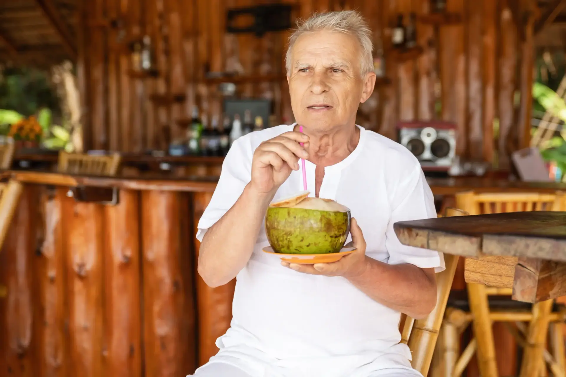 Happy senior man is drinking a coconut water, Thailand